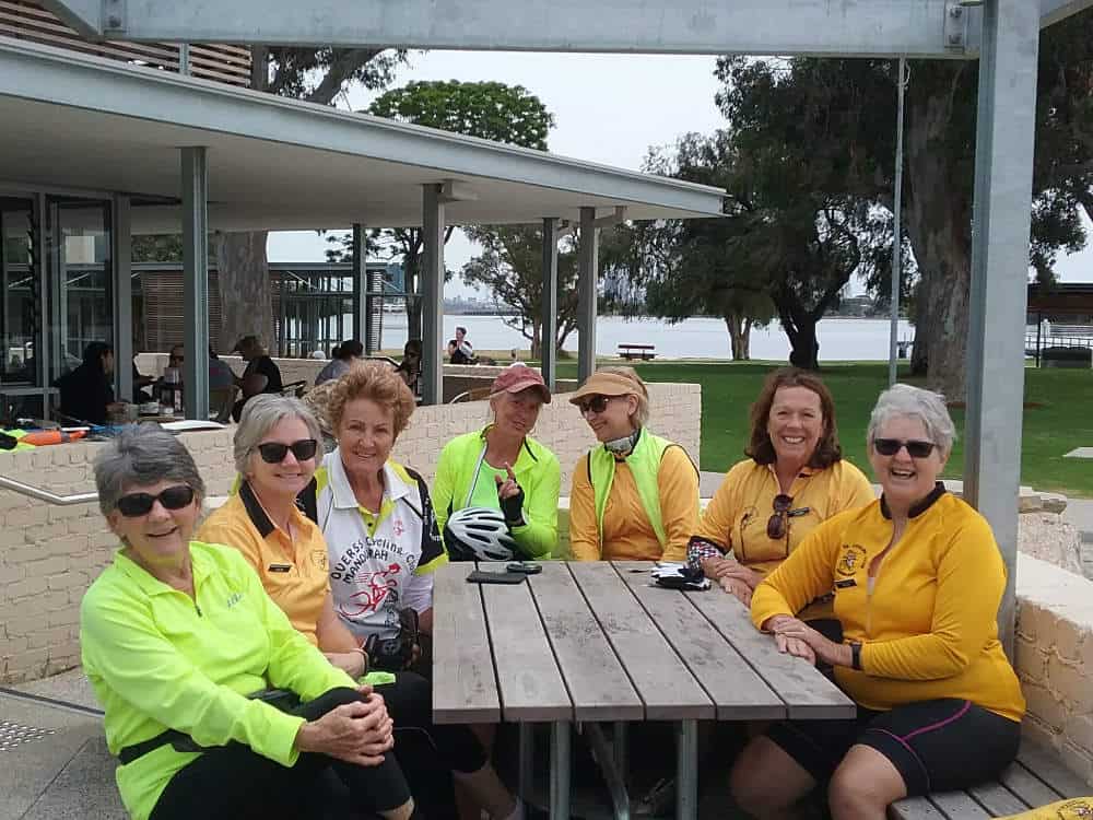 Club members in hi-vis jerseys at morning tea by the river at Mount Henry